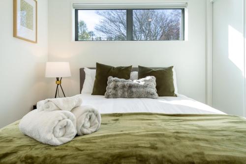 a bedroom with a bed with towels on it at Park and Stay 4BR Townhouse near Avon River in Linwood