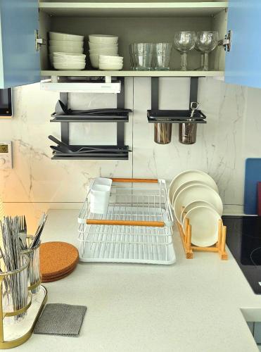 a kitchen with plates and dishes on a counter at Majestic Seoul Stay Central in Seoul