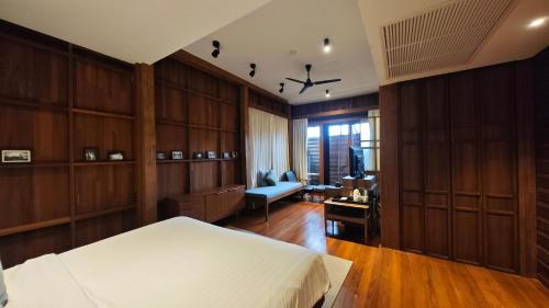 a bedroom with wooden walls and a bed and a desk at Chann Bangkok Noi in Bangkok