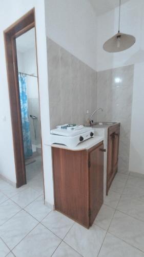 a bathroom with a sink and a mirror at Pensão Alcinda Bettencourt 100 meters to the Beachfront in Santa Maria