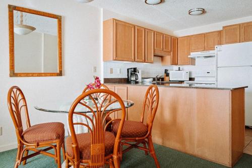 a kitchen with a table and chairs and a counter at Banyan Harbor Resort in Lihue