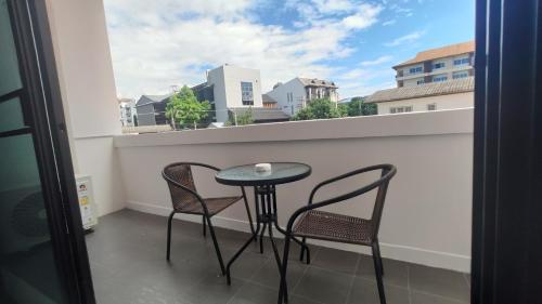 a table and two chairs on a balcony with a window at The European Chiang Mai in Chiang Mai