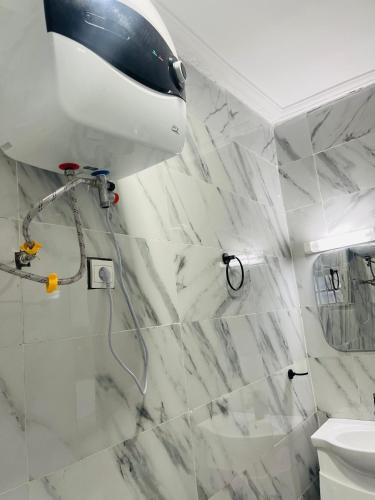 a bathroom with a shower with white marble tiles at Residence SVET in Kribi