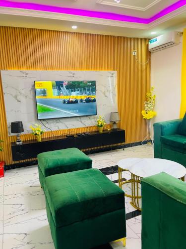 a waiting room with green chairs and a flat screen tv at Residence SVET in Kribi