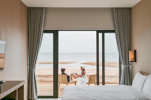 a bride and groom at the beach in a hotel room at Cape and Sea Resort in Ban Boet