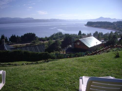 a view of a lake and a house on a hill at Cabañas Chesa Engadina in San Carlos de Bariloche