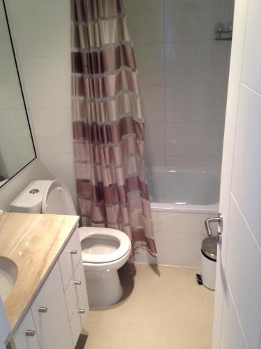 a bathroom with a toilet and a shower curtain at Jardín Del Mar 5415 in Coquimbo
