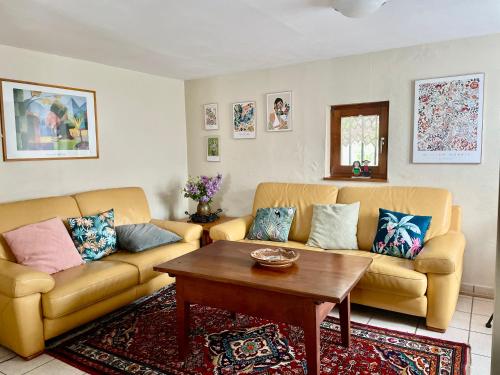 a living room with two couches and a coffee table at Gîte Nicole proche du Europa Park in Heidolsheim