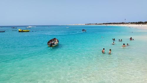 a group of people in the water on a beach at Pensão Alcinda Bettencourt 100 meters to the Beachfront in Santa Maria