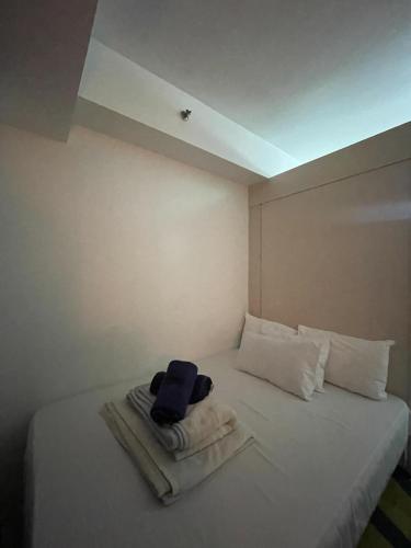 a bed with towels on it in a room at Moa Sea Residences Staycation in Manila