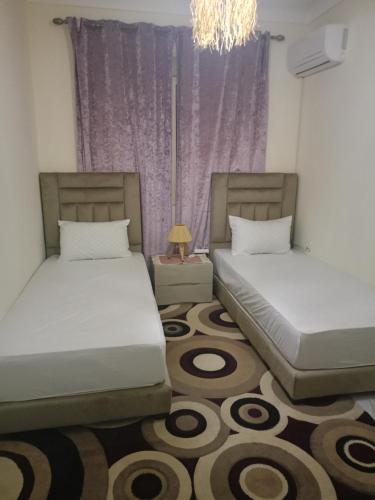 a bedroom with two beds and a chandelier at Appartement cosy et discret in Marrakesh