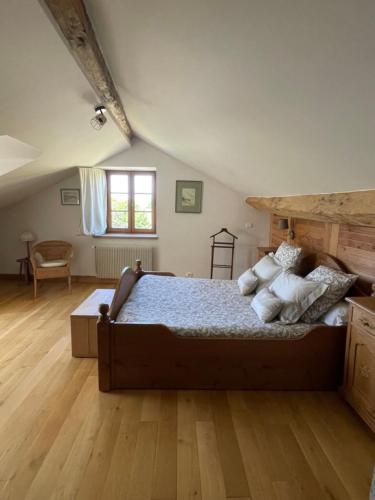 une chambre avec un grand lit avec des oreillers dessus dans l'établissement Château de GRANDVAUX, à Varennes-sous-Dun