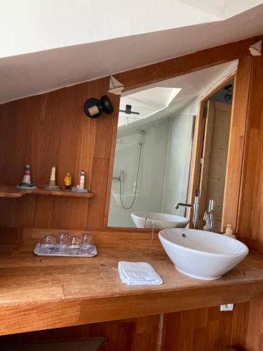 une salle de bain avec un lavabo et un grand miroir dans l'établissement Château de GRANDVAUX, à Varennes-sous-Dun