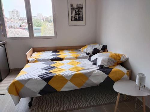 - une chambre avec 2 lits et une table dans l'établissement Studio 20 minutes Châtelet, à Gentilly