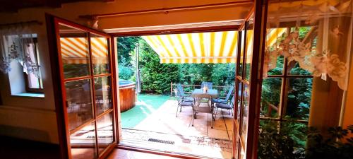 an open glass door to a patio with a table at Elitní wellness penzion U Dvou jedlí v srdci Českého ráje in Turnov