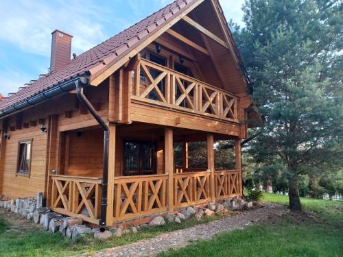 a log cabin with a gambrel roof at Domki Mazury MAX in Rybical