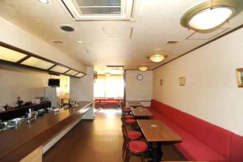 um restaurante com mesas e cadeiras e um sofá vermelho em Hokkaido Dai-ichi Hotel Sapporo em Sapporo