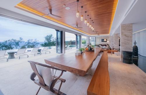 a large living room with a large wooden table and chairs at Bluesiam Villas - SHA Certified in Surin Beach