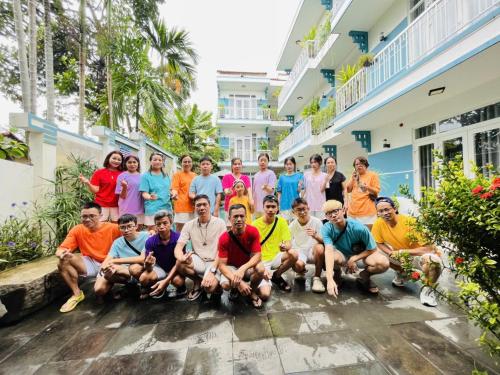 a group of people posing for a picture in front of a building at Lucky Leaf Hoian Villa in Hoi An
