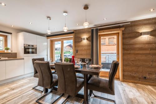 une cuisine et une salle à manger avec une table et des chaises dans l'établissement OURSON - Appartement 3 chambres / 3 salles de bains, à Morzine