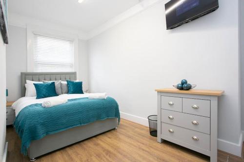 a bedroom with a bed and a dresser at Large Stylish 2bedroom flat in Wood Green in London