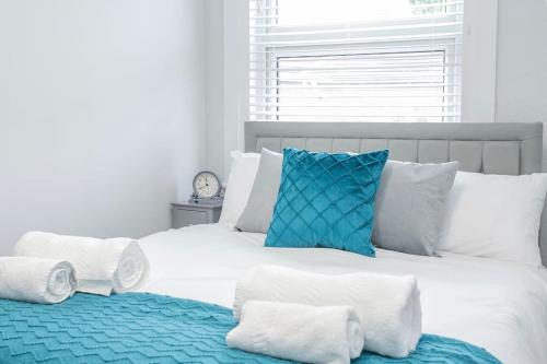 a large white bed with blue and white pillows at Large Stylish 2bedroom flat in Wood Green in London