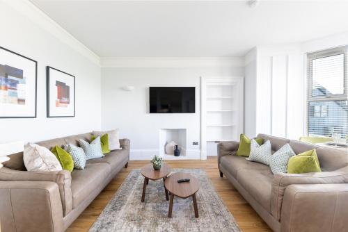 a living room with a couch and a table at Hillside Luxury Apartments in Inverness