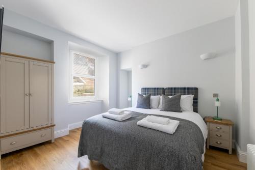 a bedroom with a bed with two towels on it at Hillside Luxury Apartments in Inverness