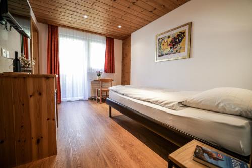 a bedroom with a large bed and a window at Hotel Sonnenhalde, Arosa in Arosa