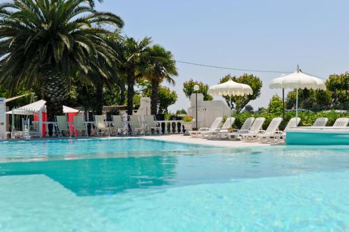 a large swimming pool with chairs and umbrellas at Camping Village Riviera in Numana