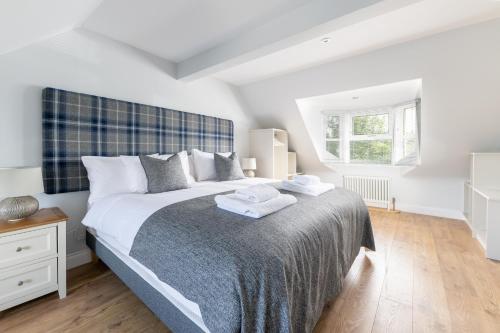 a bedroom with a large bed with towels on it at Hillside Luxury Apartments in Inverness