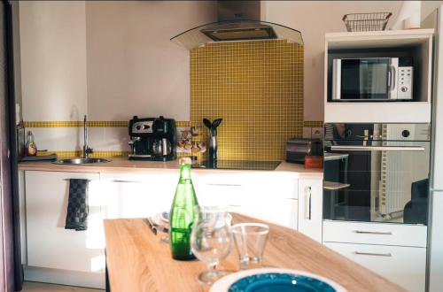 une cuisine avec une table avec des verres et une bouteille dans l'établissement Le Cosy, à Mâcon