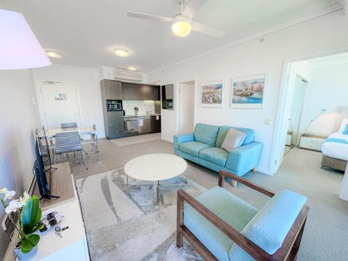 a living room with a blue couch and a table at Apartments on Connor in Brisbane
