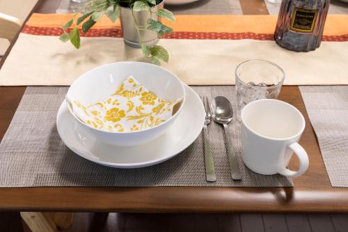 a table with a bowl and a cup on a table at Fujinomiya Base SAKUYA 一棟貸切Vacation Rental in Fujinomiya