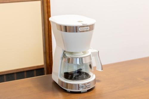 a white coffee maker sitting on a table at Fujinomiya Base SAKUYA 一棟貸切Vacation Rental in Fujinomiya