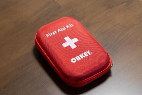 a red first aid suitcase sitting on a wooden table at Fujinomiya Base SAKUYA 一棟貸切Vacation Rental in Fujinomiya