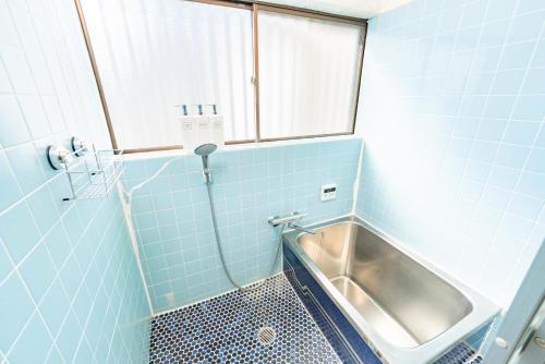 a bathroom with a tub and a sink at Fujinomiya Base SAKUYA 一棟貸切Vacation Rental in Fujinomiya