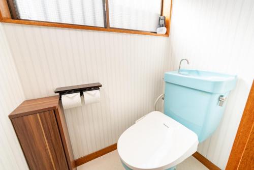 a bathroom with a blue toilet and a window at Fujinomiya Base SAKUYA 一棟貸切Vacation Rental in Fujinomiya