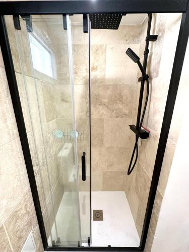 une douche avec une porte vitrée dans une salle de bain dans l'établissement Le Cocon de Montpellier - Hyper-Centre, Standing & Confortable, Full Équipé, à Montpellier