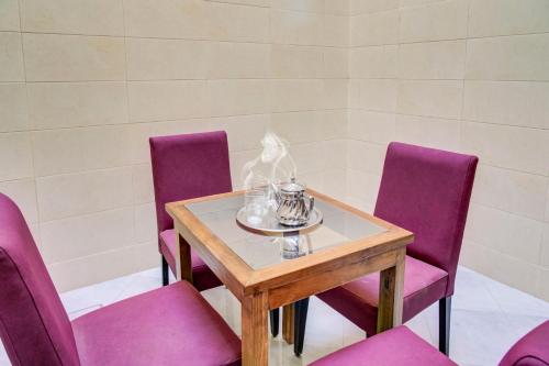 a table with purple chairs and a wooden table with a bowl on it at jaws wave imsouane in Imsouane