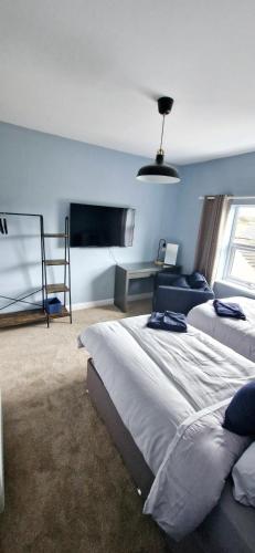 a bedroom with two beds and a window at The willow tree inn in Pilsley