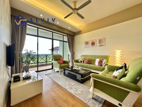 a living room with green furniture and a large window at Costa Mahkota - 1min I Mahkota Parade Mall I Dataran Pahlawan I Mahkota Hospital in Melaka