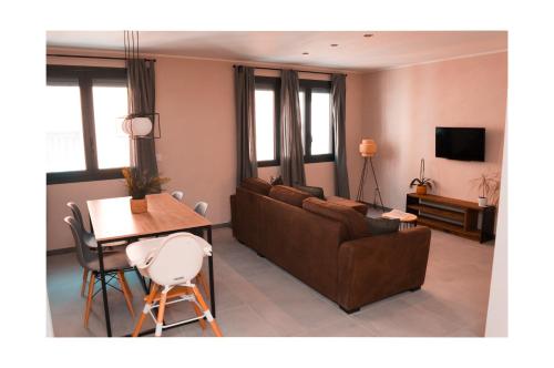 a living room with a couch and a table at Le Petit Cathare, Nid rénové au cœur de Quillan in Quillan