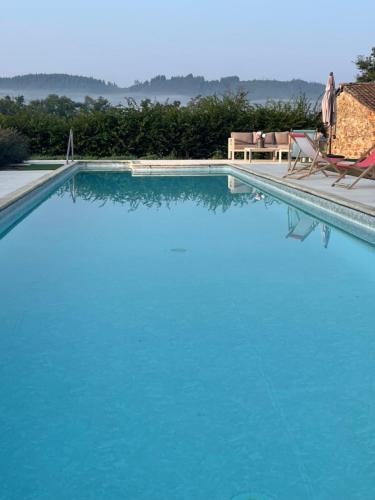 - une grande piscine bleue avec 2 chaises dans l'établissement Château de GRANDVAUX, à Varennes-sous-Dun