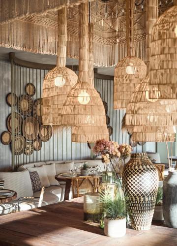 a restaurant with straw chandeliers and tables and chairs at Ikos Andalusia in Estepona