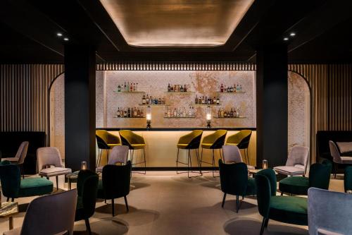 a waiting room with yellow chairs and a bar at Ikos Andalusia in Estepona