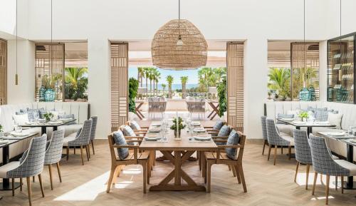 a dining room with a long table and chairs at Ikos Andalusia in Estepona