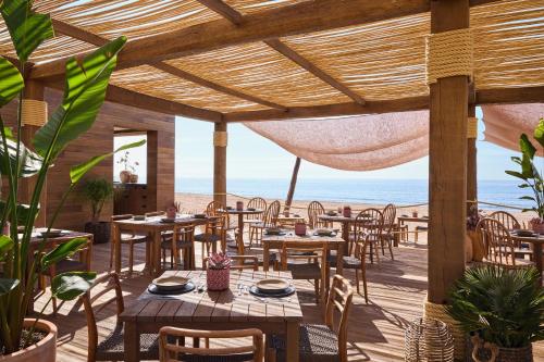 a restaurant on the beach with tables and chairs at Ikos Andalusia in Estepona