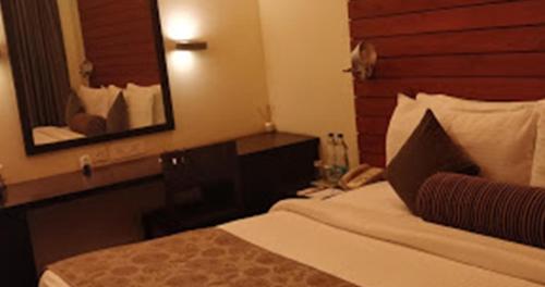 a hotel room with a bed and a mirror at The Golkonda Resort and Spa in Hyderabad