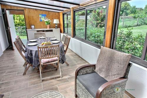 une véranda avec une table et des chaises dans l'établissement Ar vag, à Ploubazlanec